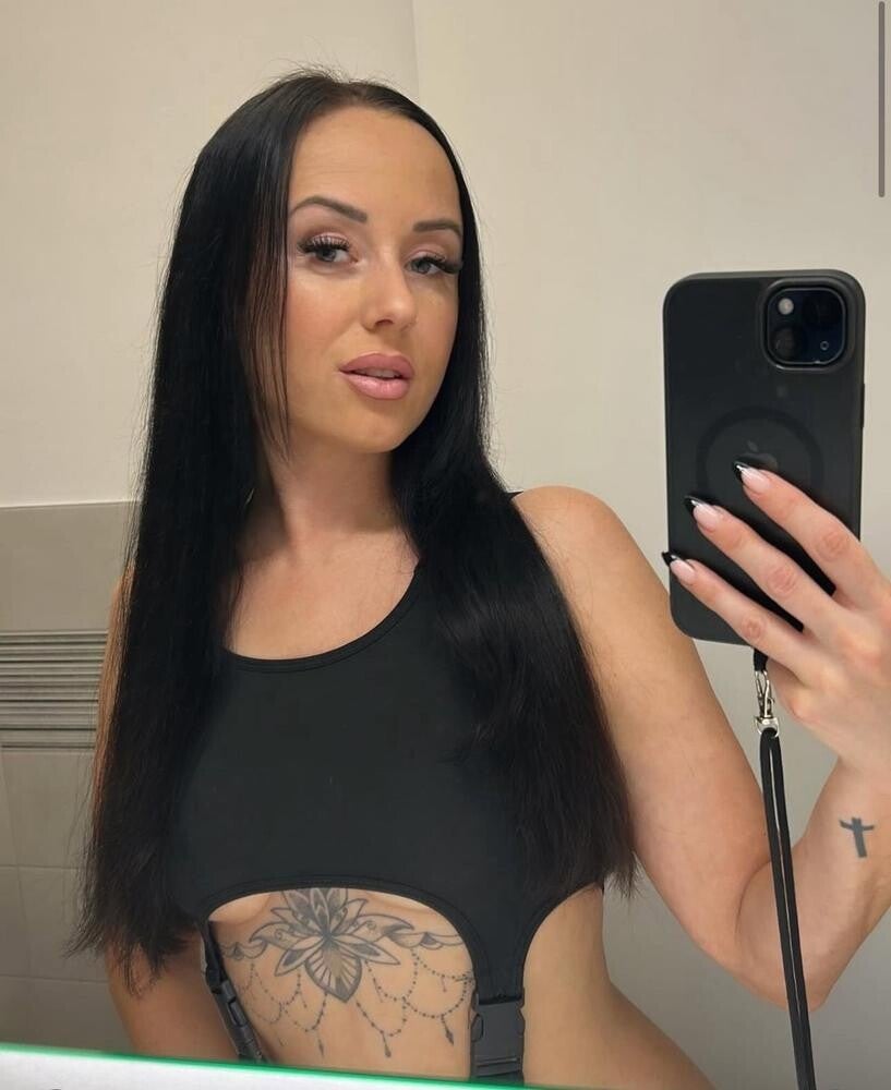Mila Jane Tattoo Model mit langen schwarzen Haaren und Bauch-Tattoo im sexy Selfie – jetzt direkt online chatten