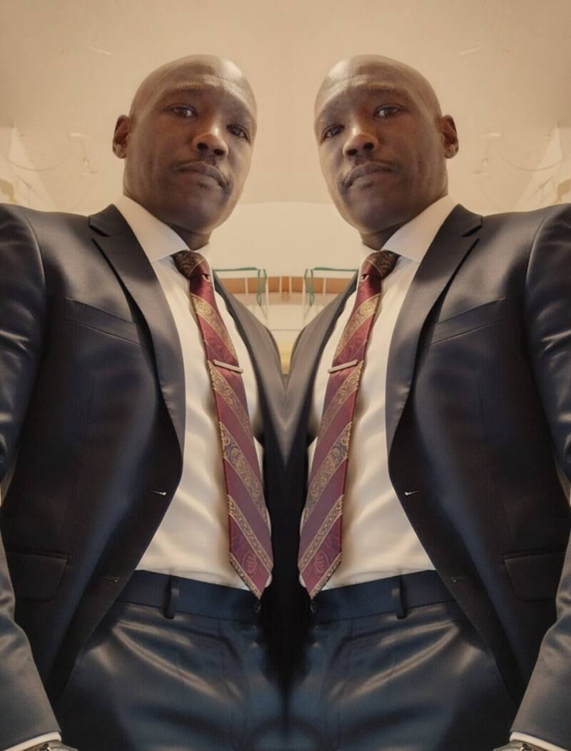 Owner of REC Yard Apparel Maurice Miller dressed in business suit and tie looking confident.