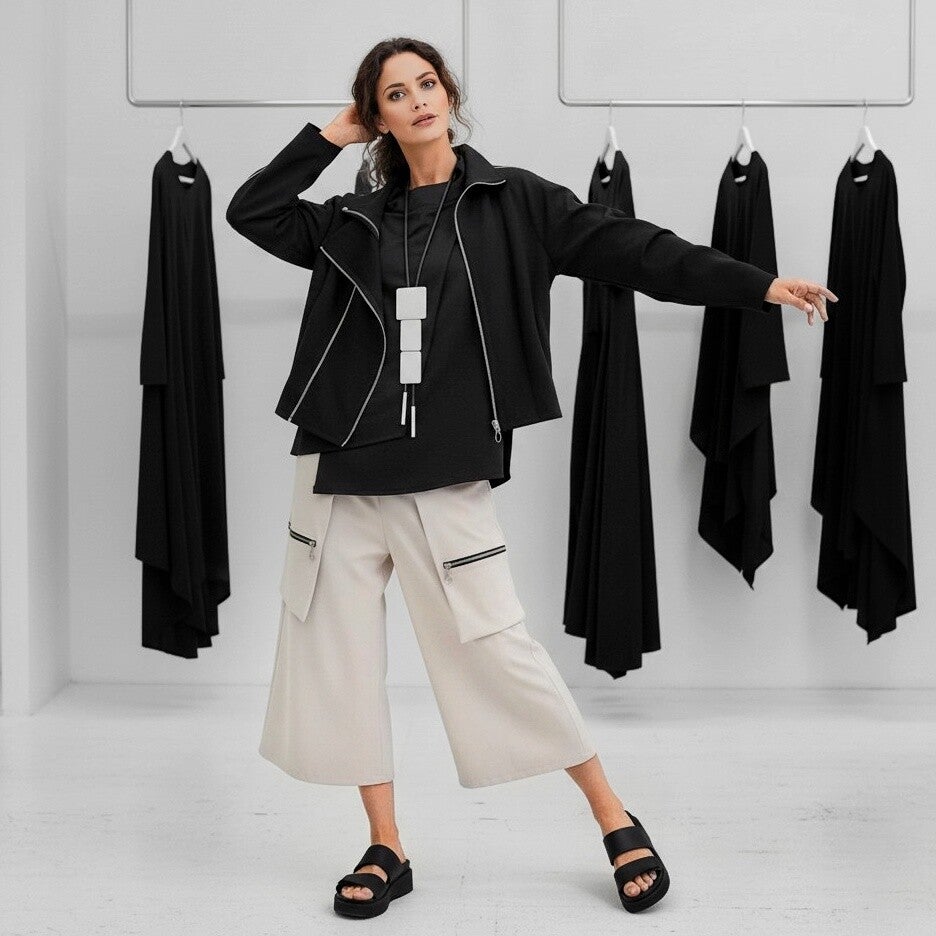 eine attraktive Frau trägt ein exklusives schwarzes Outfit  als Abendgarderobe 