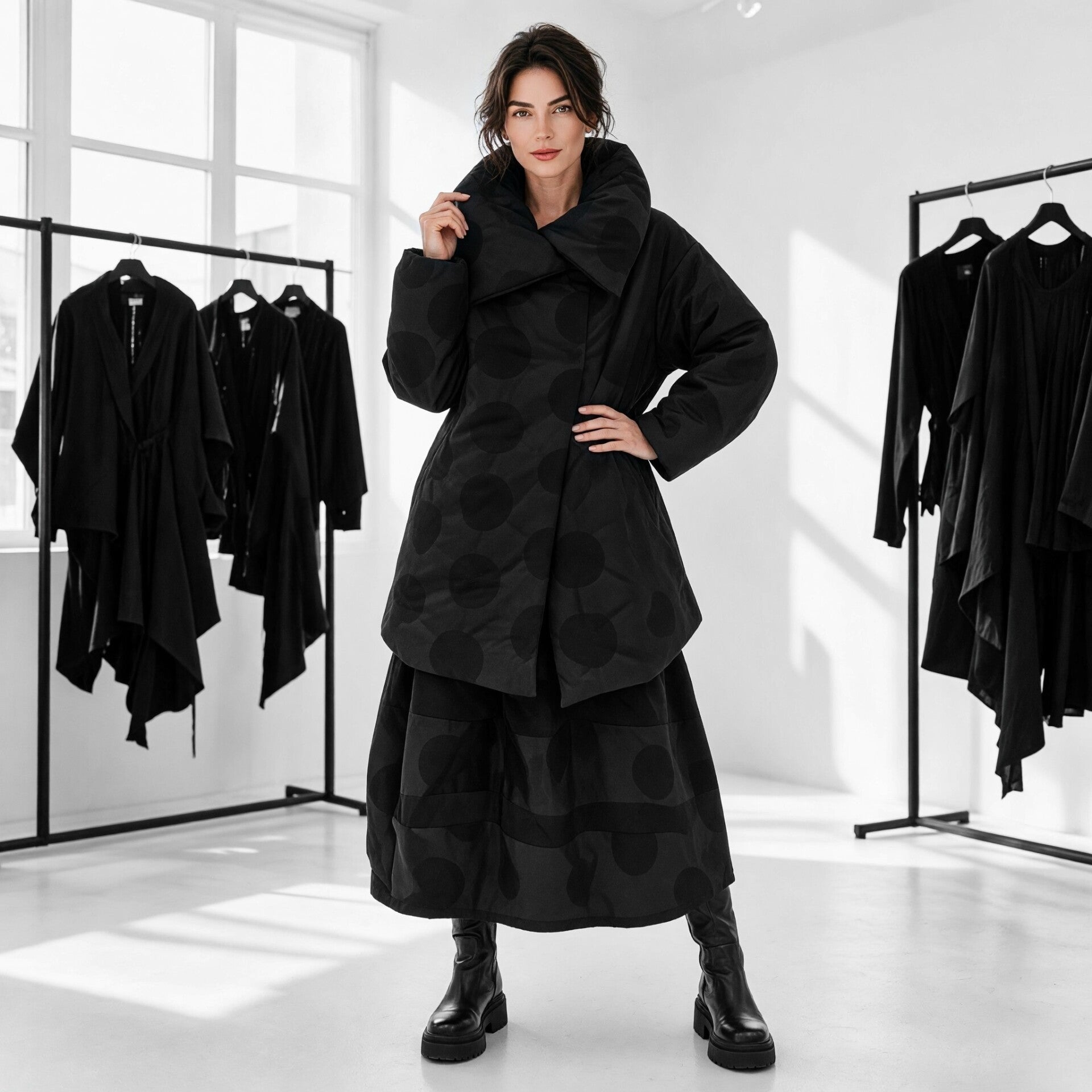 Eine sehr avantgardistisch gekleidetes Model präsentiert ein  extravagantes schwarzes Outfit 