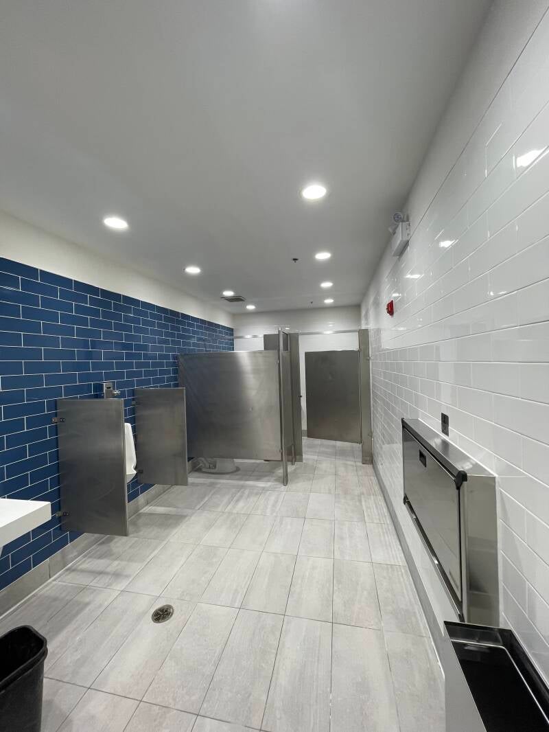 Clean modern restroom with polished tiles, stainless fixtures, and well‑maintained stalls showcasing professional commercial cleaning quality.