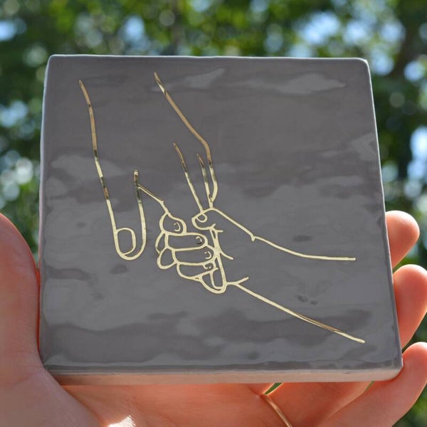 Hand ouder/verzorger en kind - goud/grijs.