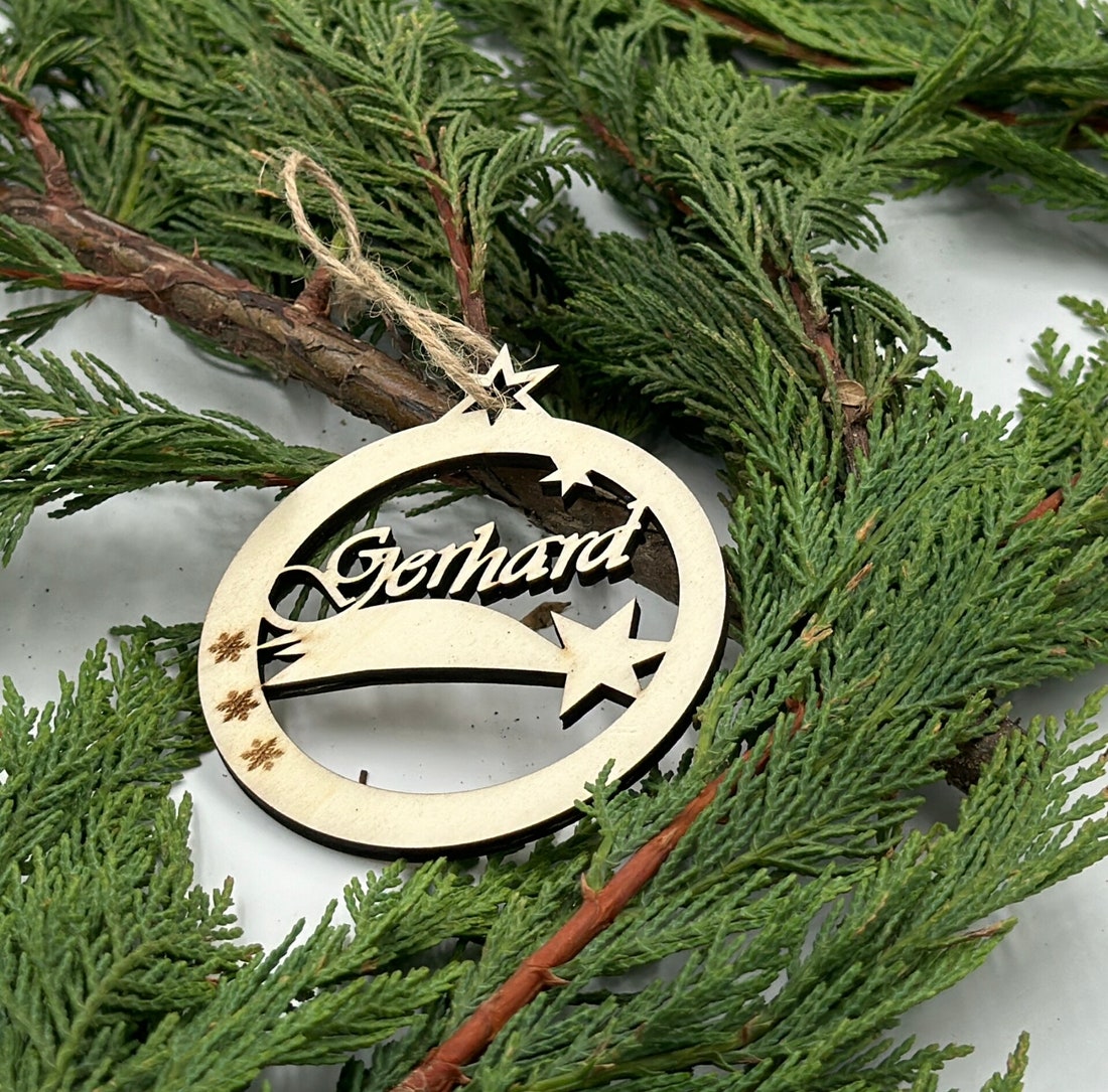 Filigrane Weihnachtskugel aus Holz mit Namen Gerhard und Sternen auf Tannenzweigen