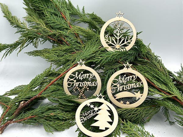 Weihnachtsanhänger aus Holz auf Tannenzweigen