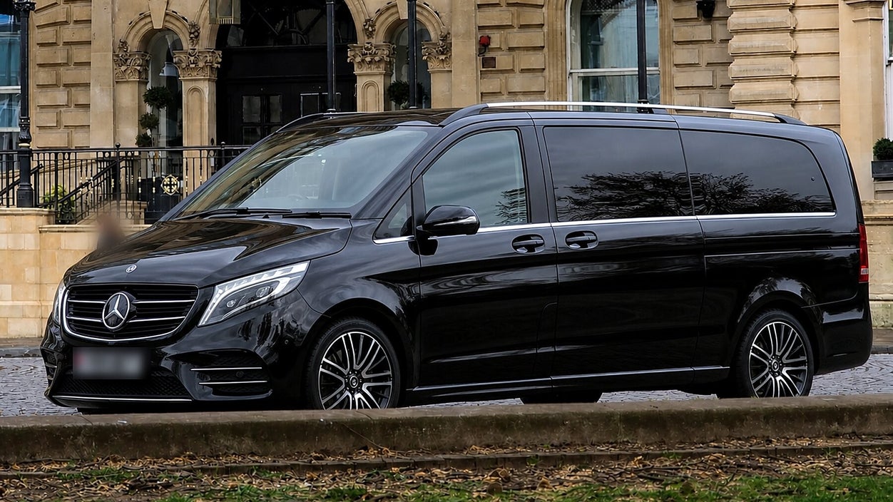 Black Mercedes-Benz V-Class executive MPV waiting outside a period hotel entrance