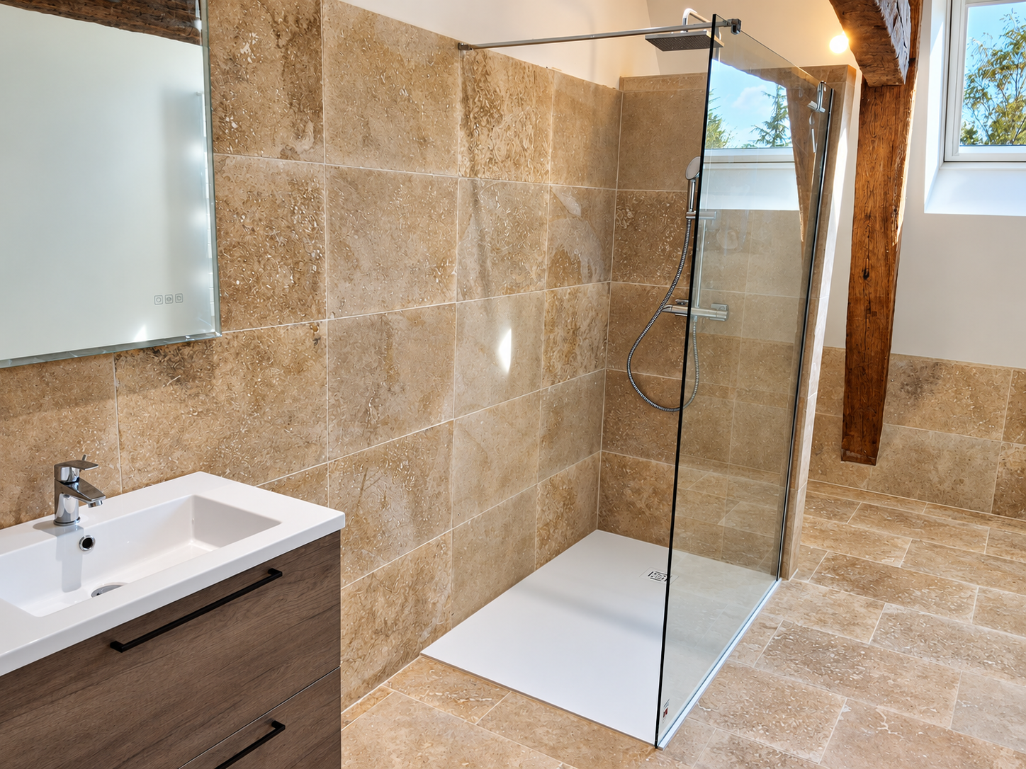 Salle d’eau rénovée avec douche vitrée et travertin