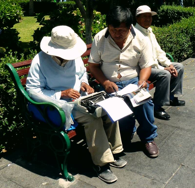 Straattypist met een ouderwetse typemachine op het Plaza de Armas in Arequipa, Peru, waar tegen betaling documenten worden opgesteld.