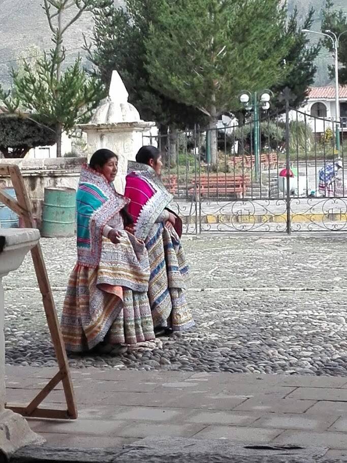 Twee vrouwen in kleurrijke traditionele geborduurde kleding op een plein in de Colca-vallei in Peru.
