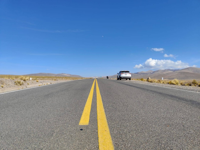 Auto rijdt over de Pan-Amerikaanse snelweg tijdens een rondreis door Peru.