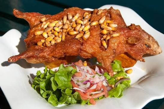 Traditioneel Peruaans gerecht met cuy (cavia), geserveerd als hele cuy of gefileerd met aardappelen en maïs.