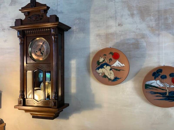 Vintage wandklok met koperen wijzerplaat en mechanisch uurwerk