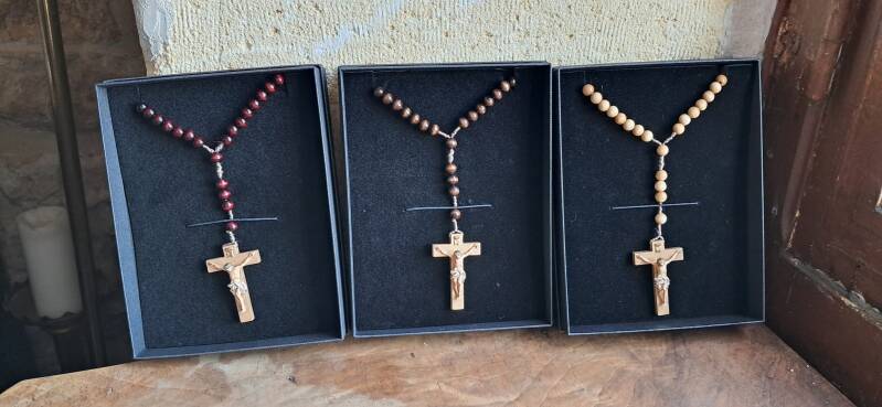 Trois chapelets vendus par l'atelier statuaire, fabriqués à la main en Italie, avec des croix sculptées et peintes artisanalement.