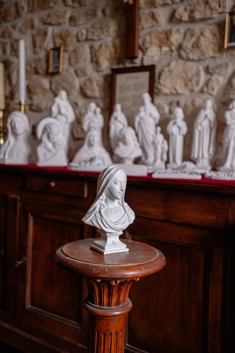 Petit buste de la Vierge Marie regardant humblement vers le bas reproduit en plâtre blanc dans l'un des derniers ateliers de fabrication de statues religieuses traditionnelles.