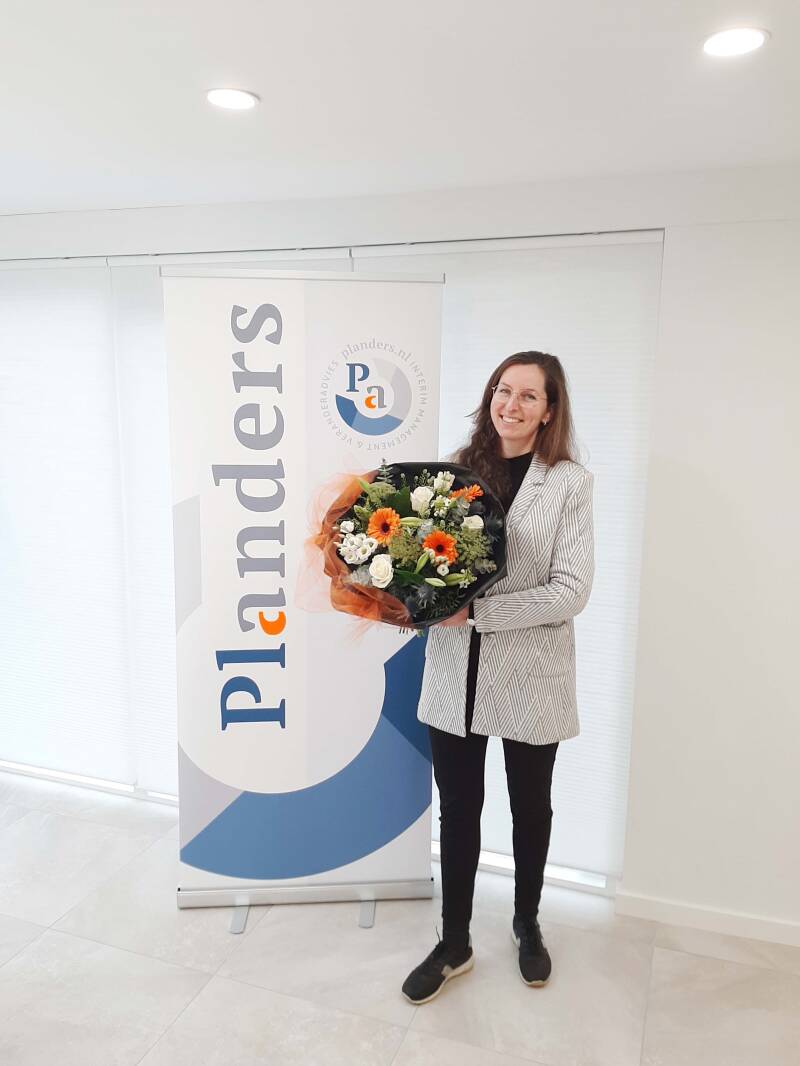 foto van Veerle Vreeke voor de promotiebanner van Panders met een grote mooie bosbloemen in haar handen in de kleuren van huisstyle van Planders