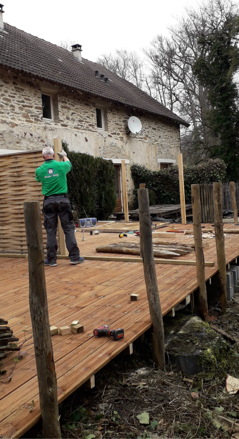 Fred plaats schermen op het terras van een vakantiewoning in Frankrijk.
