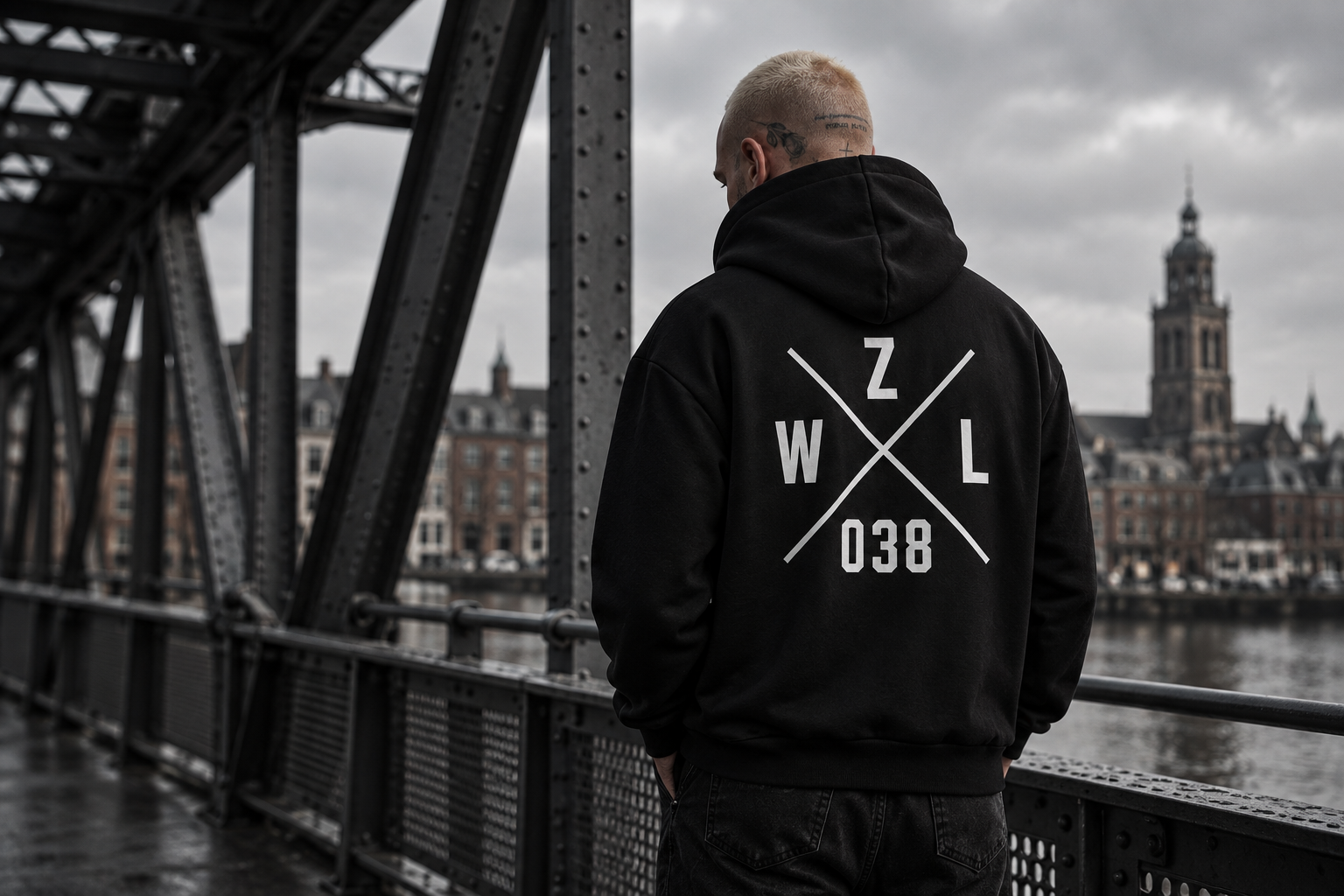 038 DISTRICT sfeerbeeld: zwarte hoodie met witte ZWL 038-rugprint bij een stalen brug