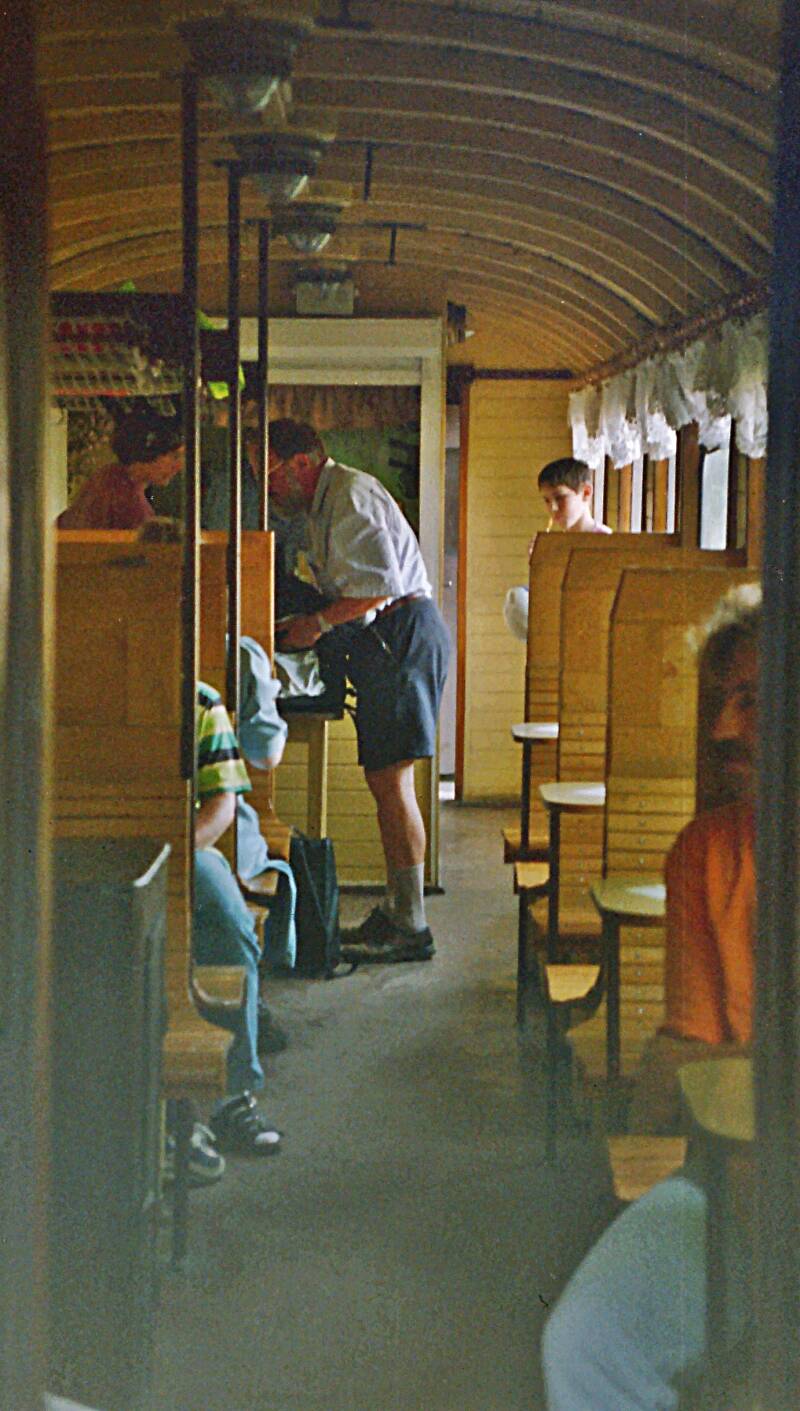 auf Holzsitzen mit Gardinen vor den Fenstern. Nostalgie pur