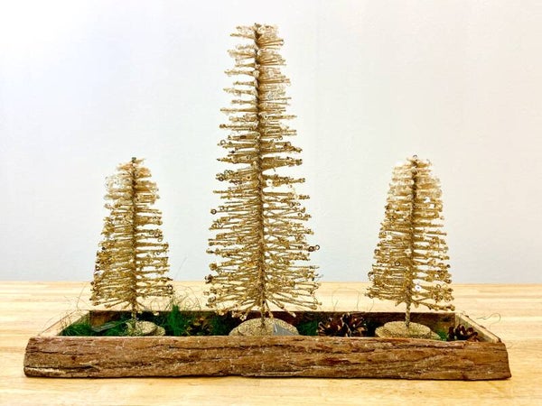 Gouden kerstbomen in een houten schaal