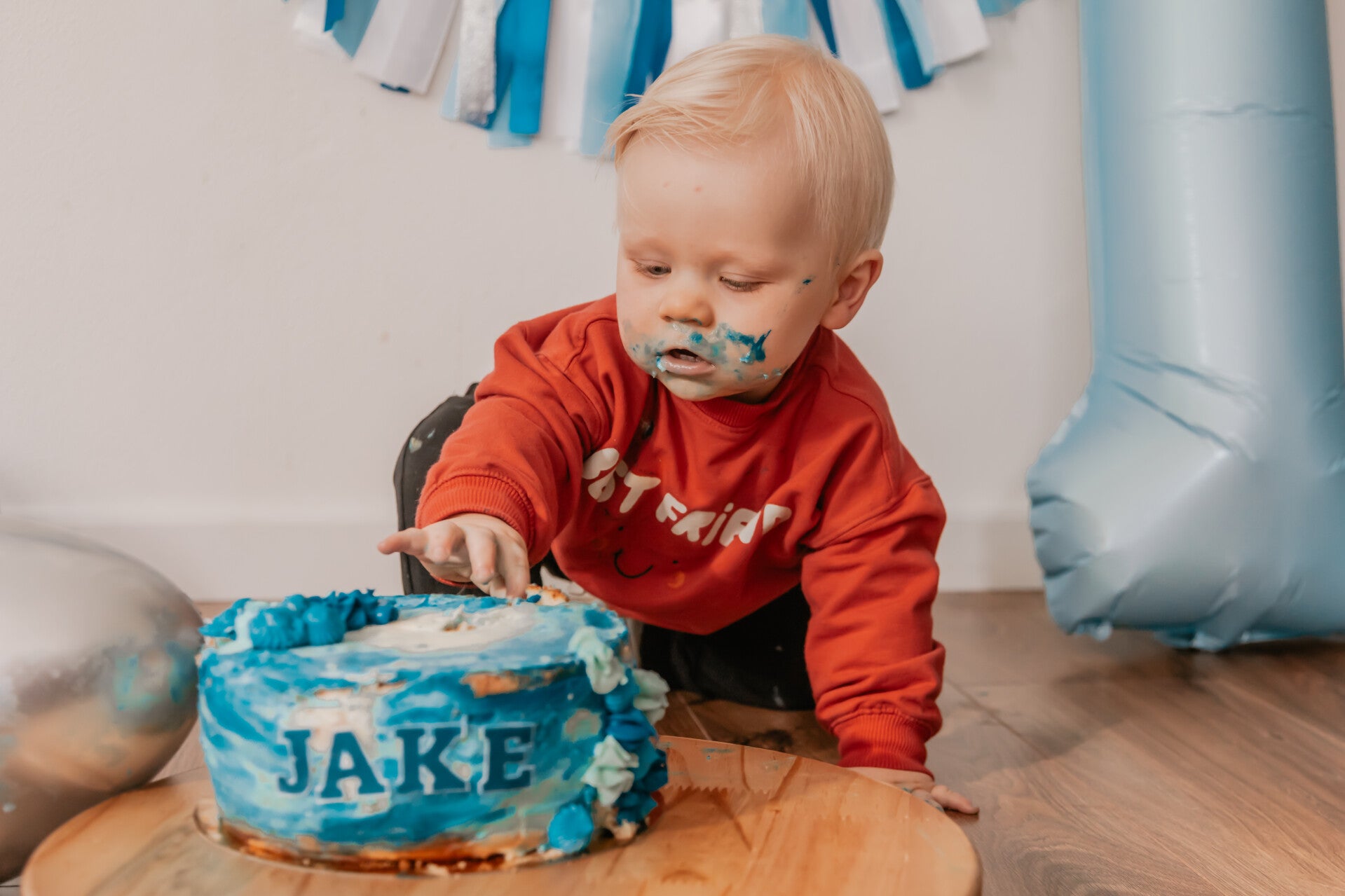 Detailopname van een baby met taart aan de handjes tijdens een cakesmash fotoshoot bij Marleen v.d. Wal.