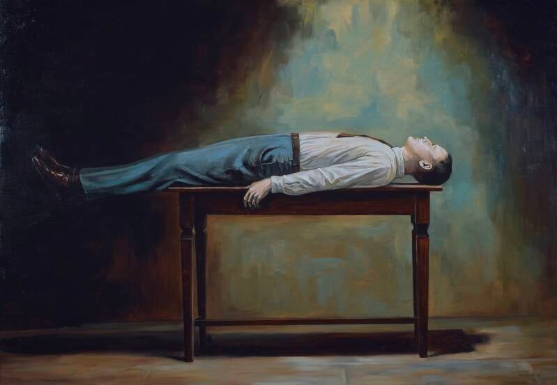 man ligt horizontaal op een tafel