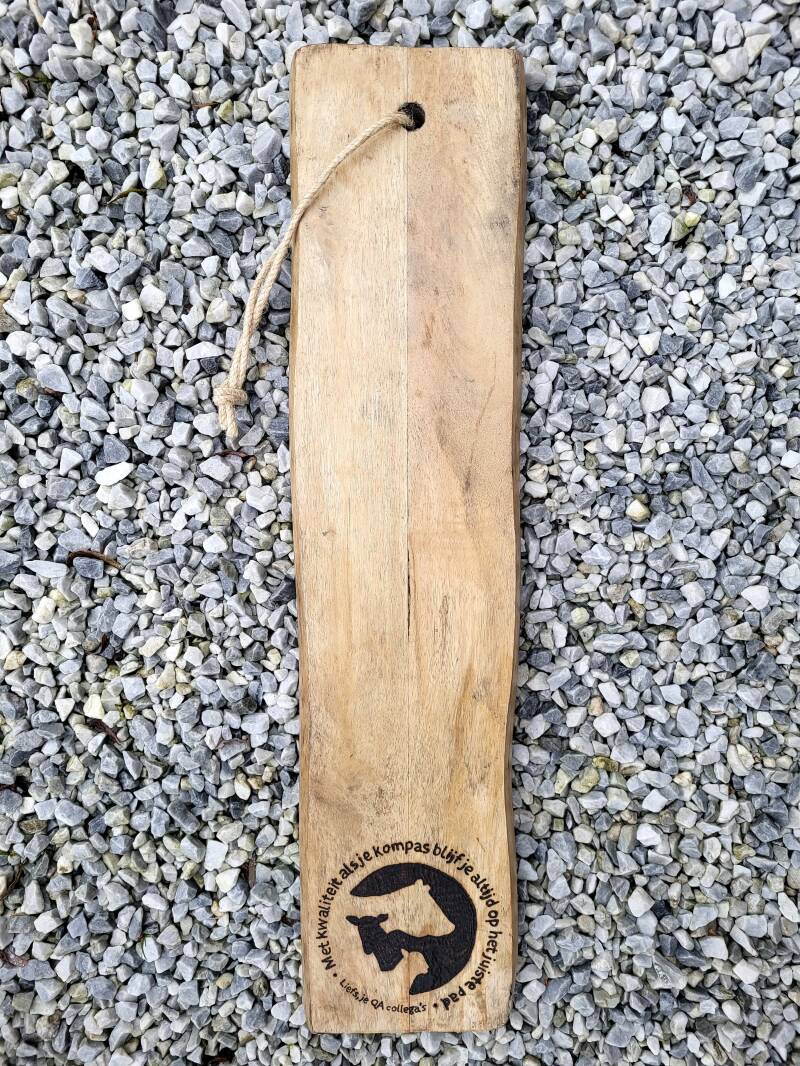 Eigen gebrachte mangohouten plank houtgebrand met een logo en tekst: Met kwalitieit als je kompas blijf je altijd op het juiste pad. 