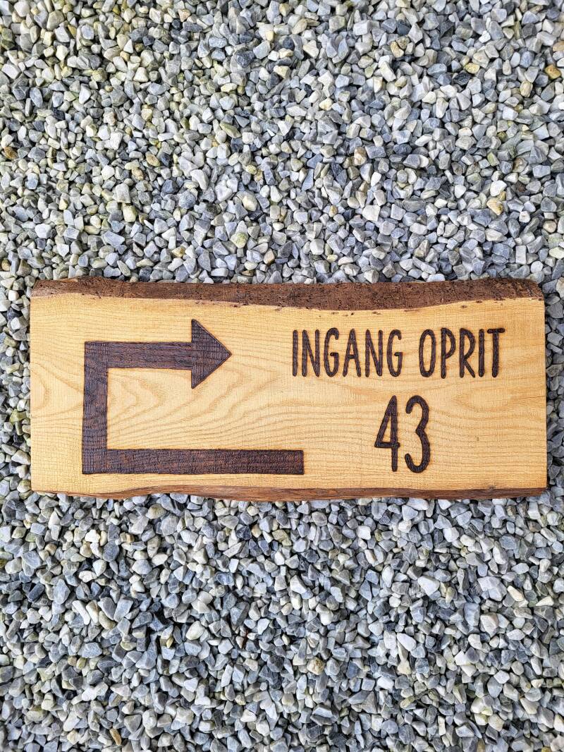 Eiken houten plank houtgebrand met wegwijzering erop. 