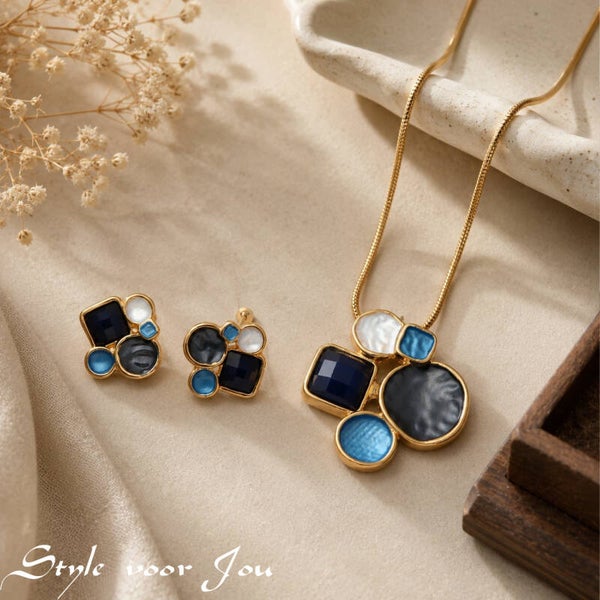Deze prachtige set artistieke sieraden betovert met de harmonieuze combinatie van geëmailleerde elementen en subtiele glinstering.