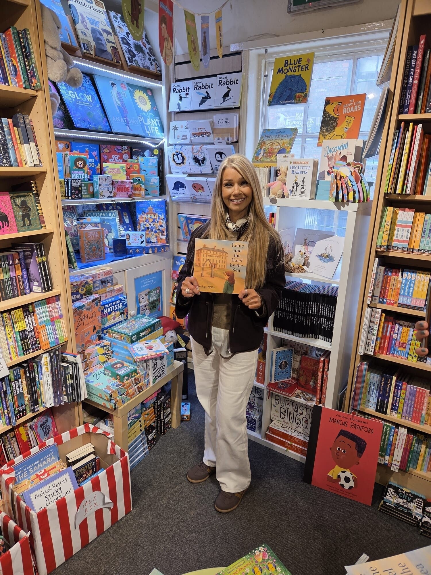 Author Penelope Willis in Whitby Bookshop holding Lottie and the Hotel by the Sea, a gentle bedtime story inspired by Whitby and the Royal Hotel