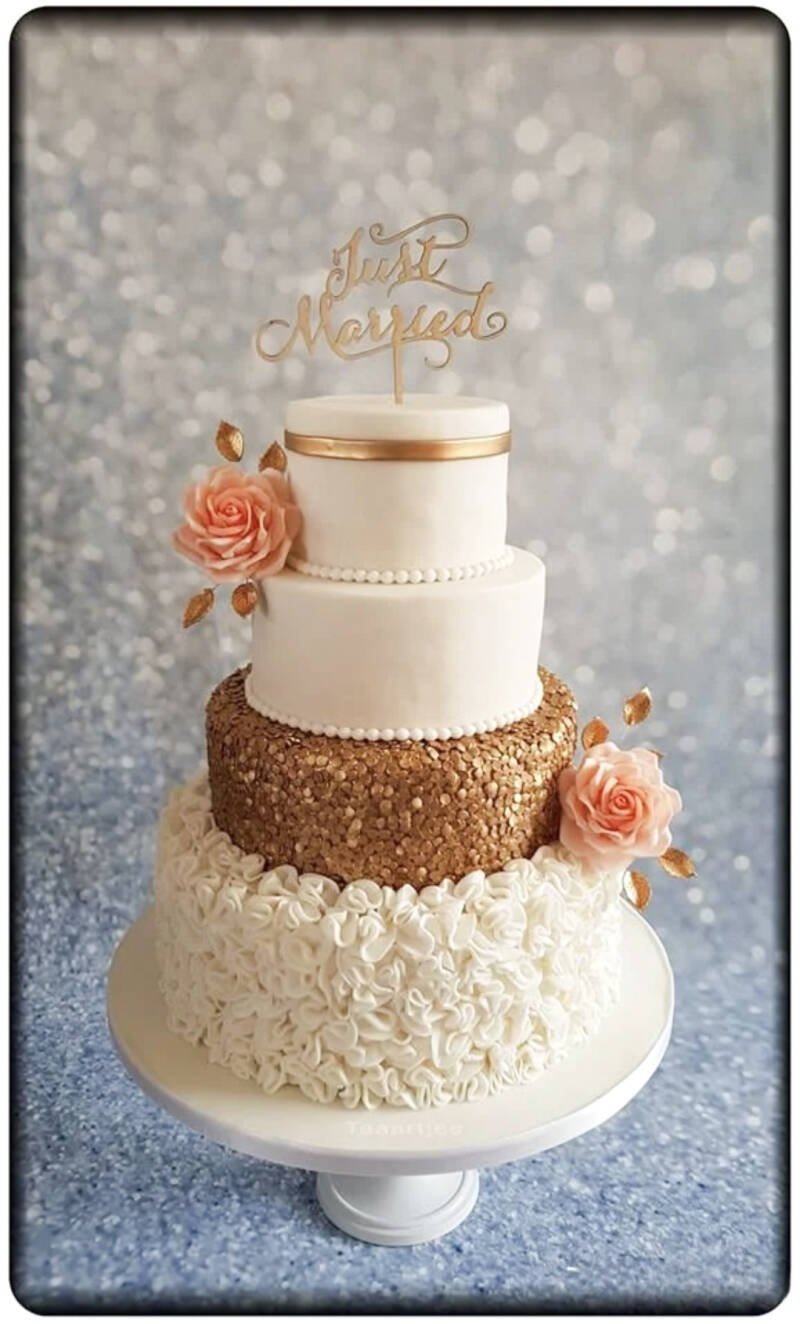Prachtige bruidstaart met zalm handgemaakte rozen en gouden sprinkles 