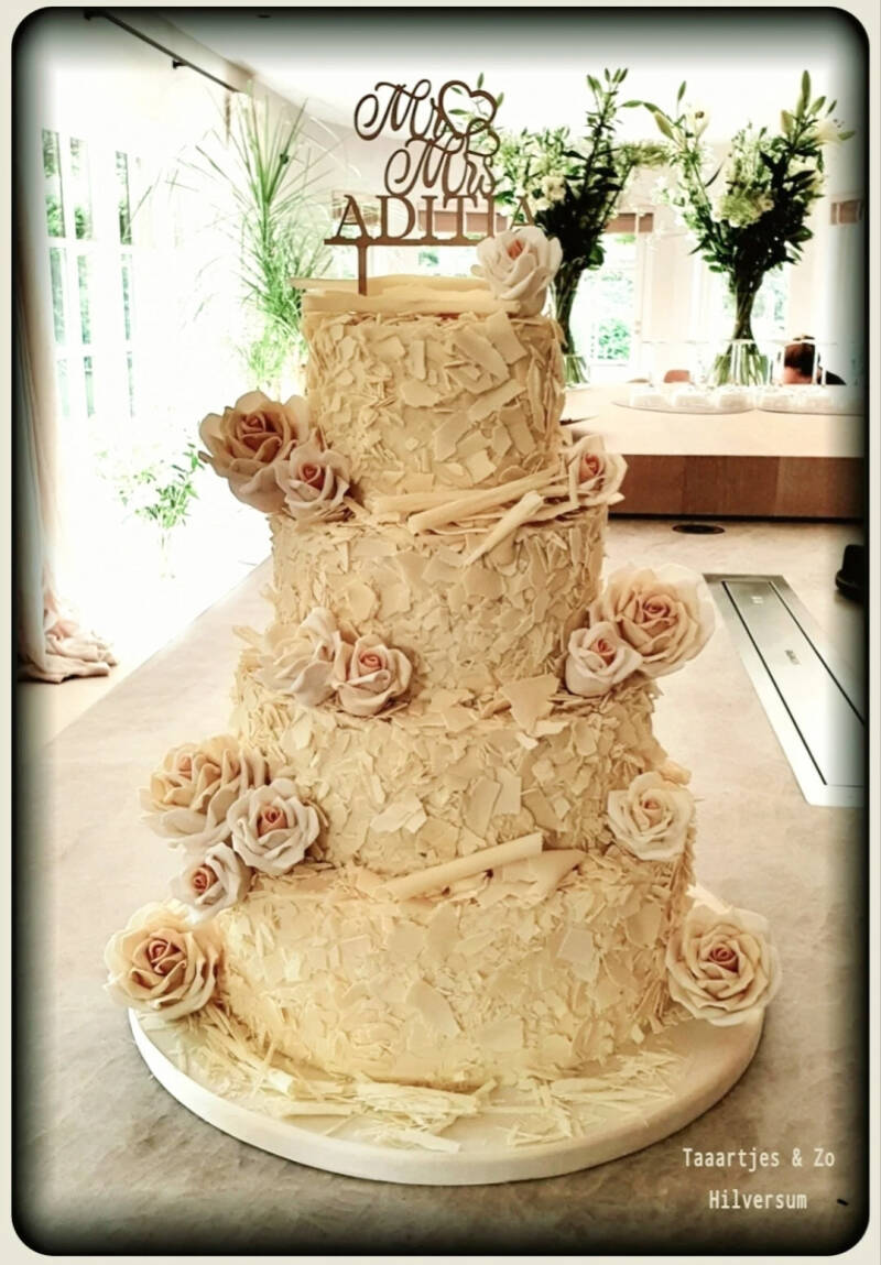 Prachtige bruidstaart met witte chocoladeschilfers en handgemaate rozen Taaartjes Hilversum 