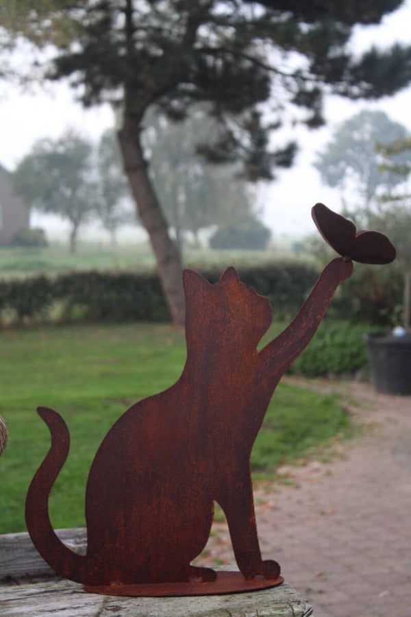 Kat met uitgestrekte poot en vlinder op poot staal roest