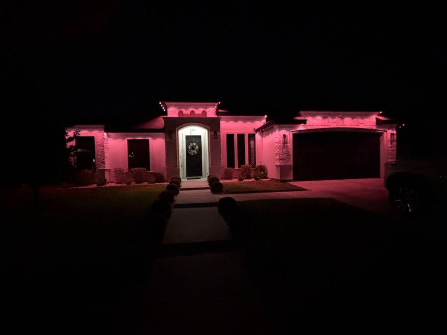 Home illuminated with pink exterior accent lighting after dark
