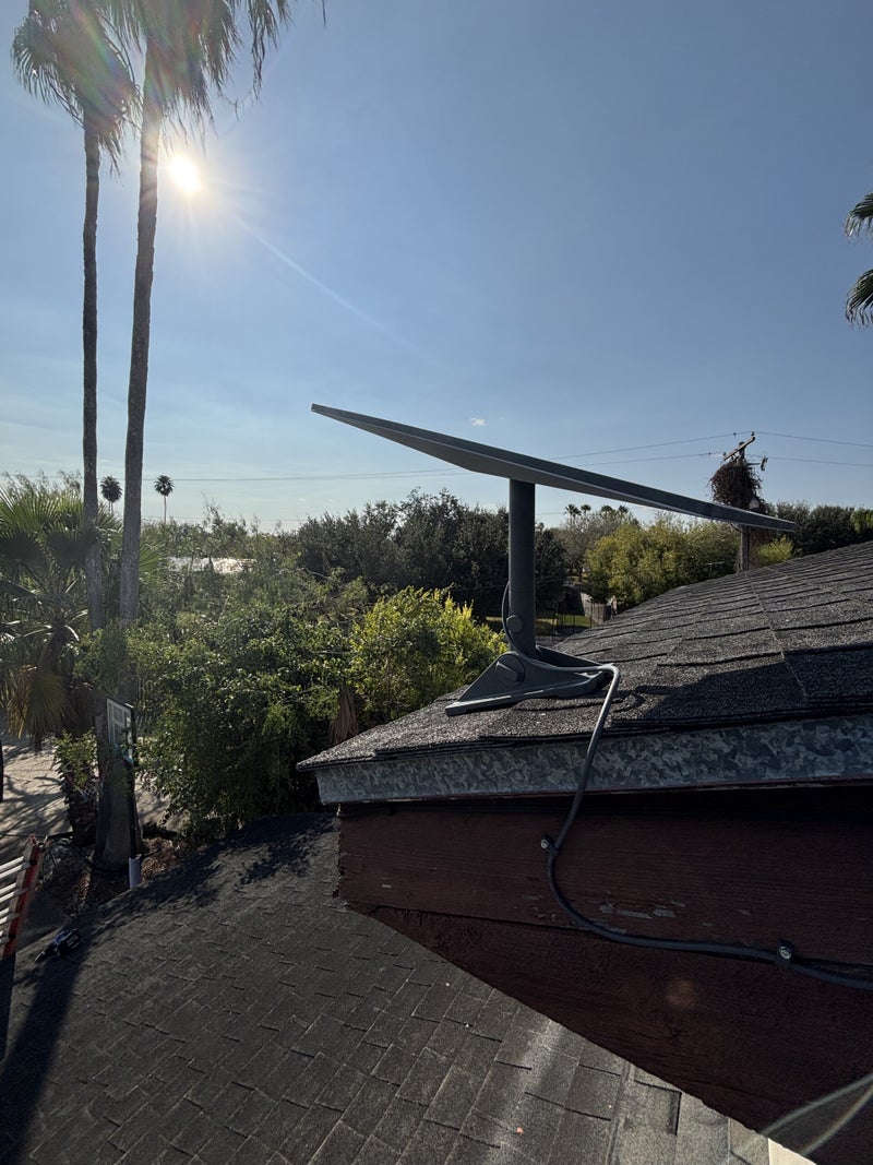 Starlink dish mounted on a shingle roof with an exterior cable path