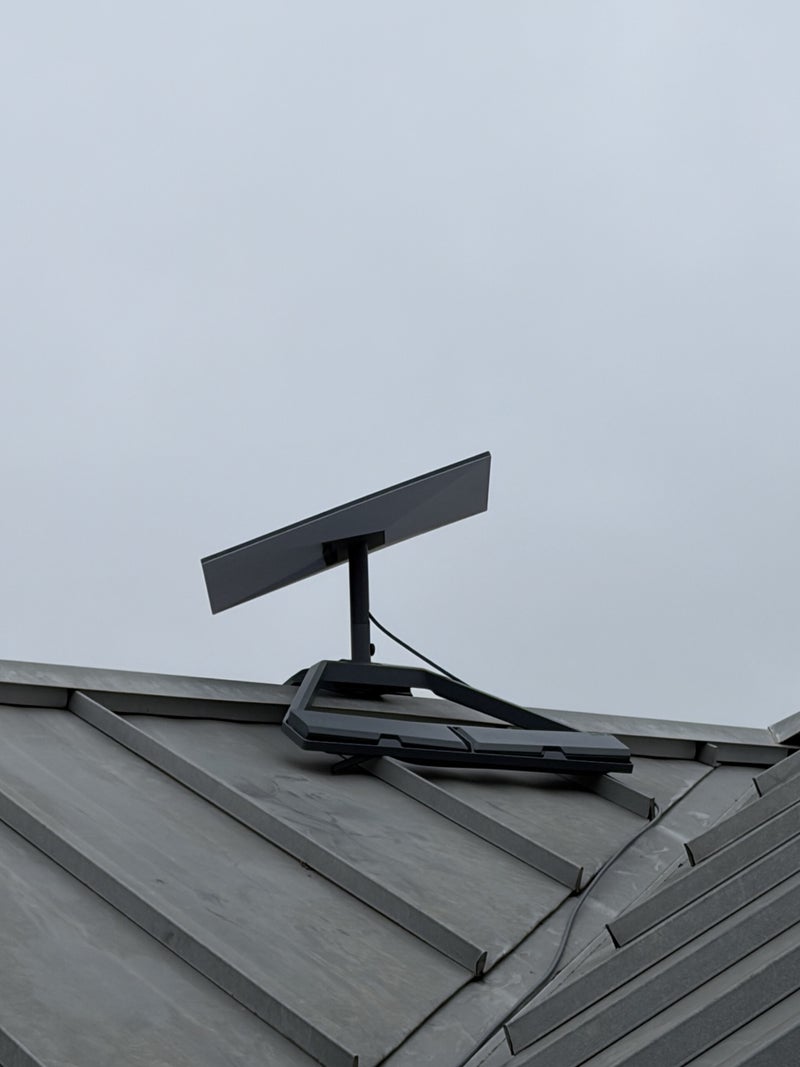 Close view of a Starlink dish and ridge mount on a metal roof