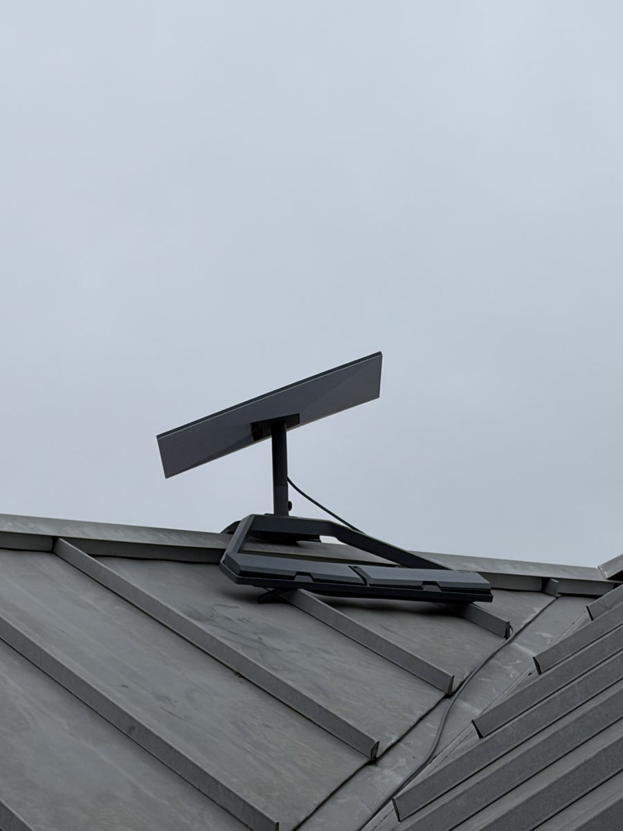 Close view of a Starlink dish and ridge mount on a metal roof