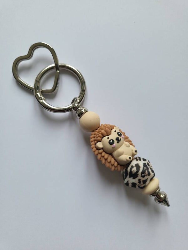 Tashanger met egeltje in beige en tijgerprint.