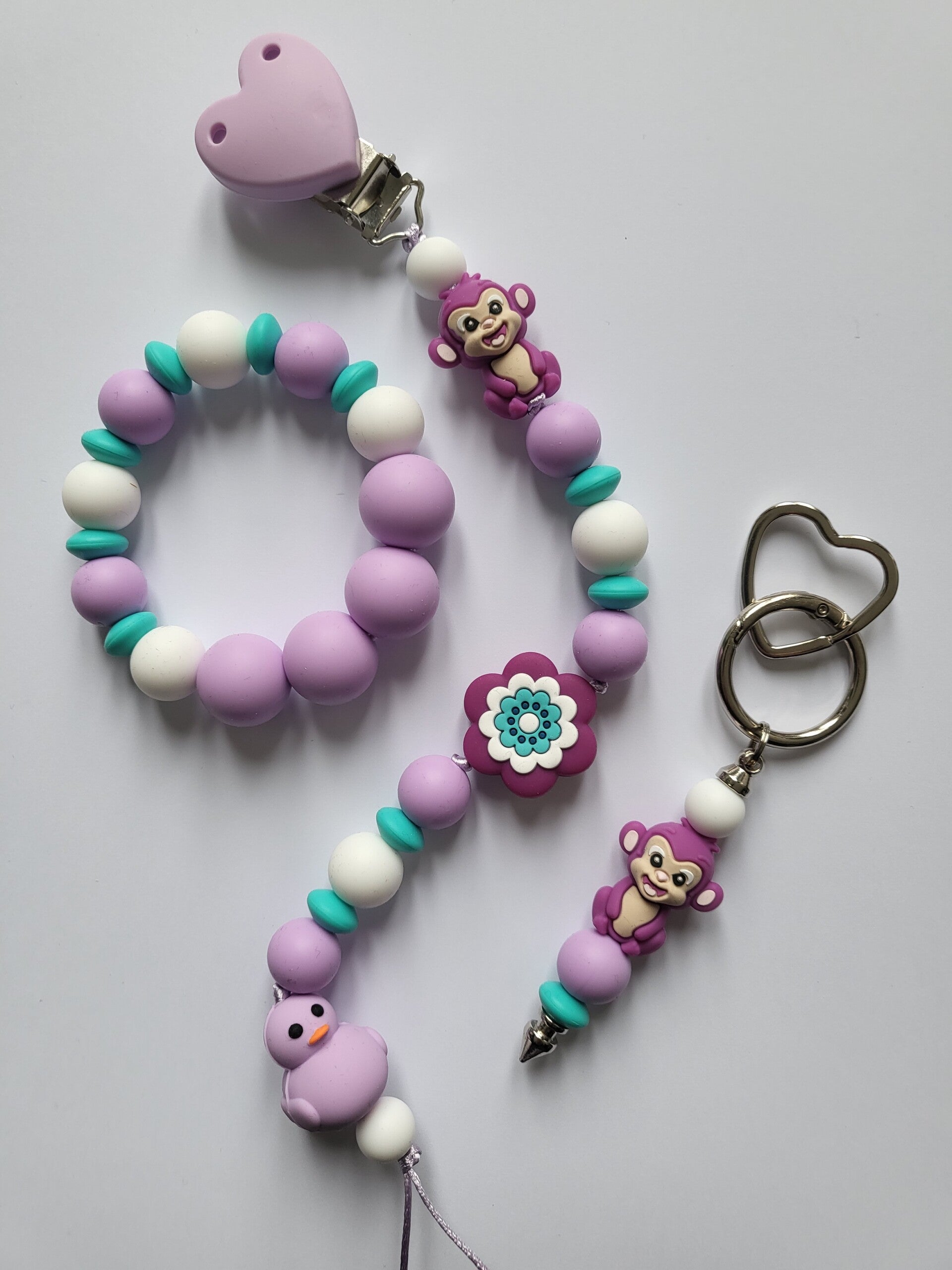 Speenkoord en bijtring met aapje en bad-eendje in lila, turquoise en wit.