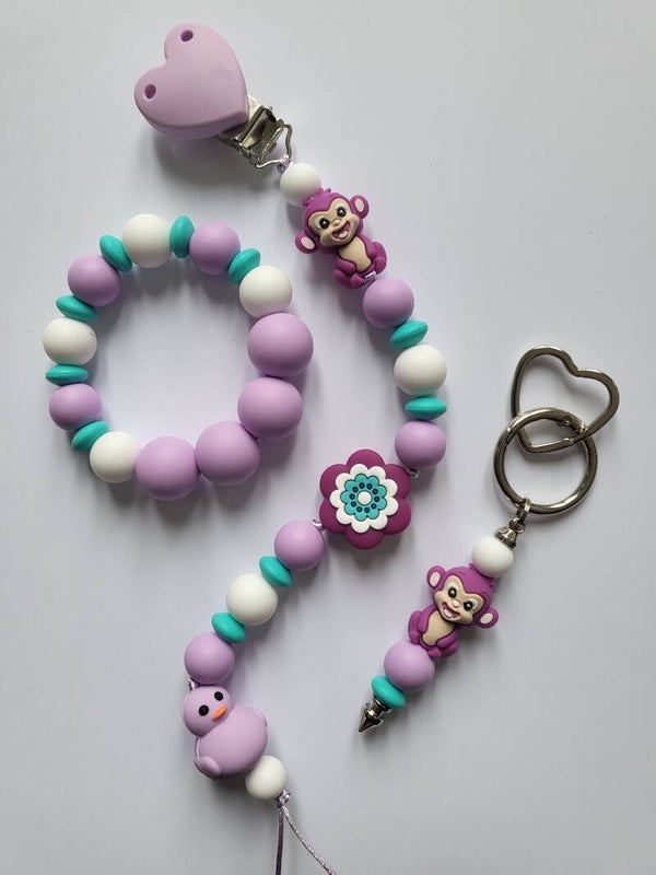 Speenkoord en bijtring met aapje en bad-eendje in lila, turquoise en wit.