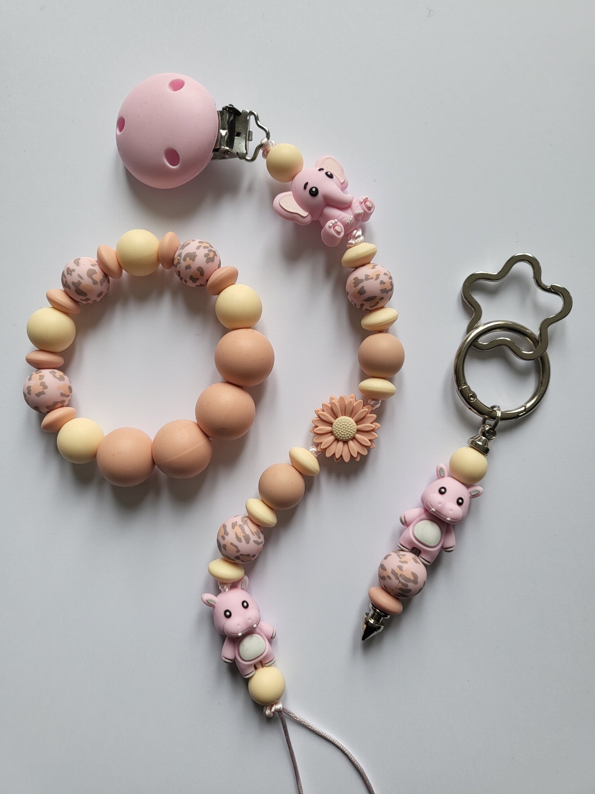 Speenkoord en bijtring met olifantje en nijlpaardje in roze, zalm en lichtgeel.
