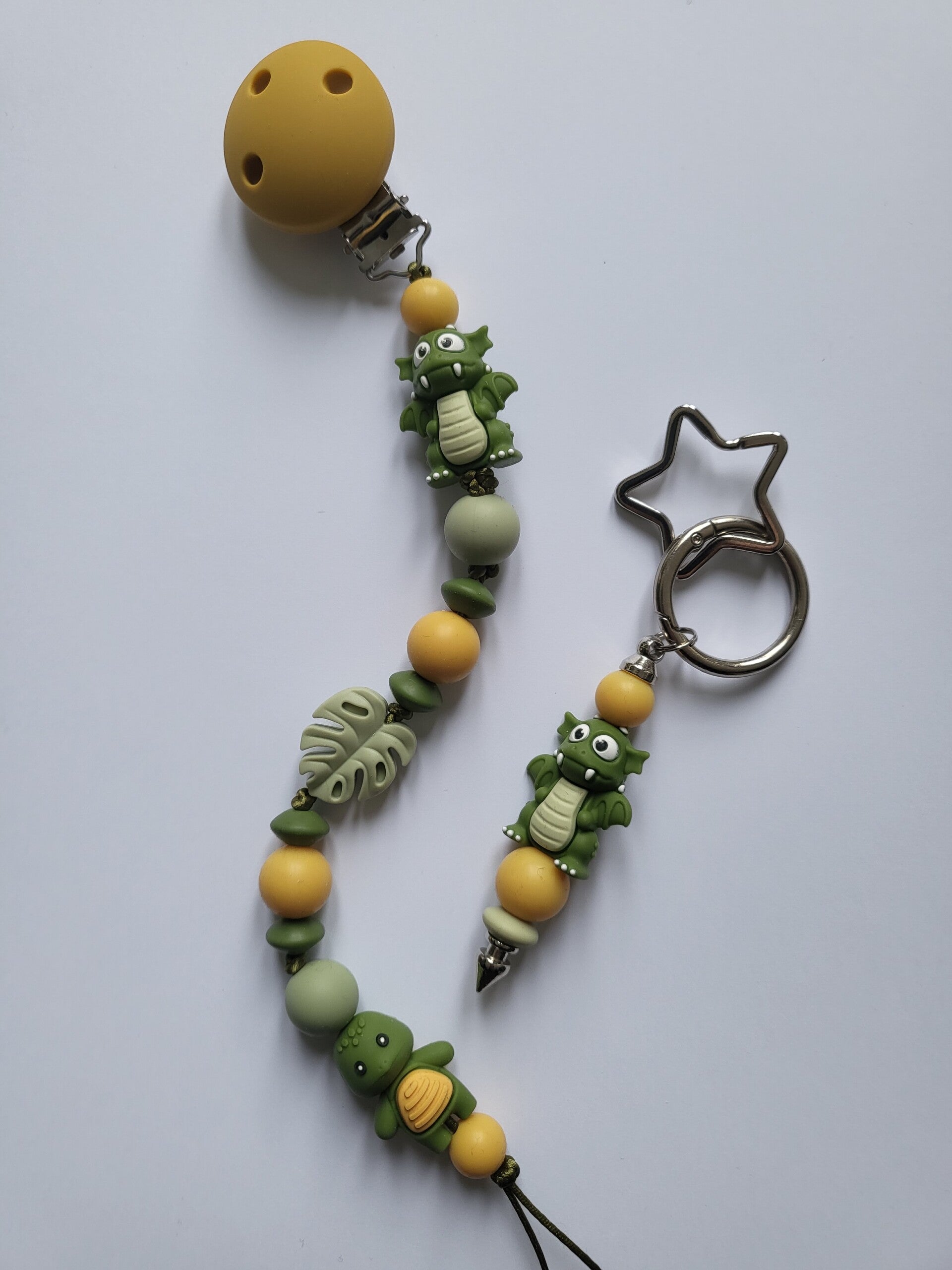 Speenkoord met draakje en schildpadjein legergroen, matcha-groen en okergeel.
