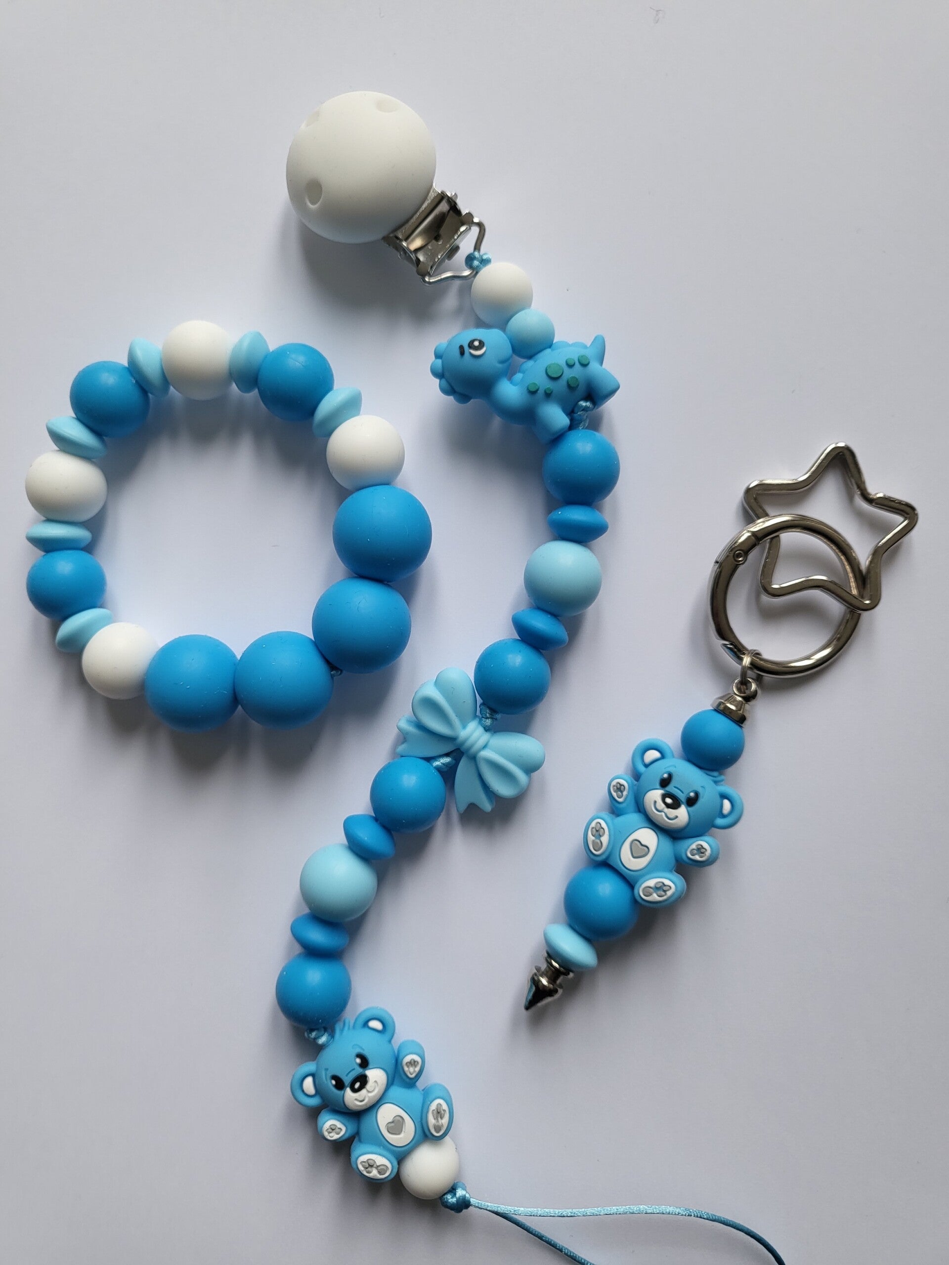 Speenkoord en bijtring met teddybeertje en dinosaurusje in kobaltblauw, zee-blauw en wit.