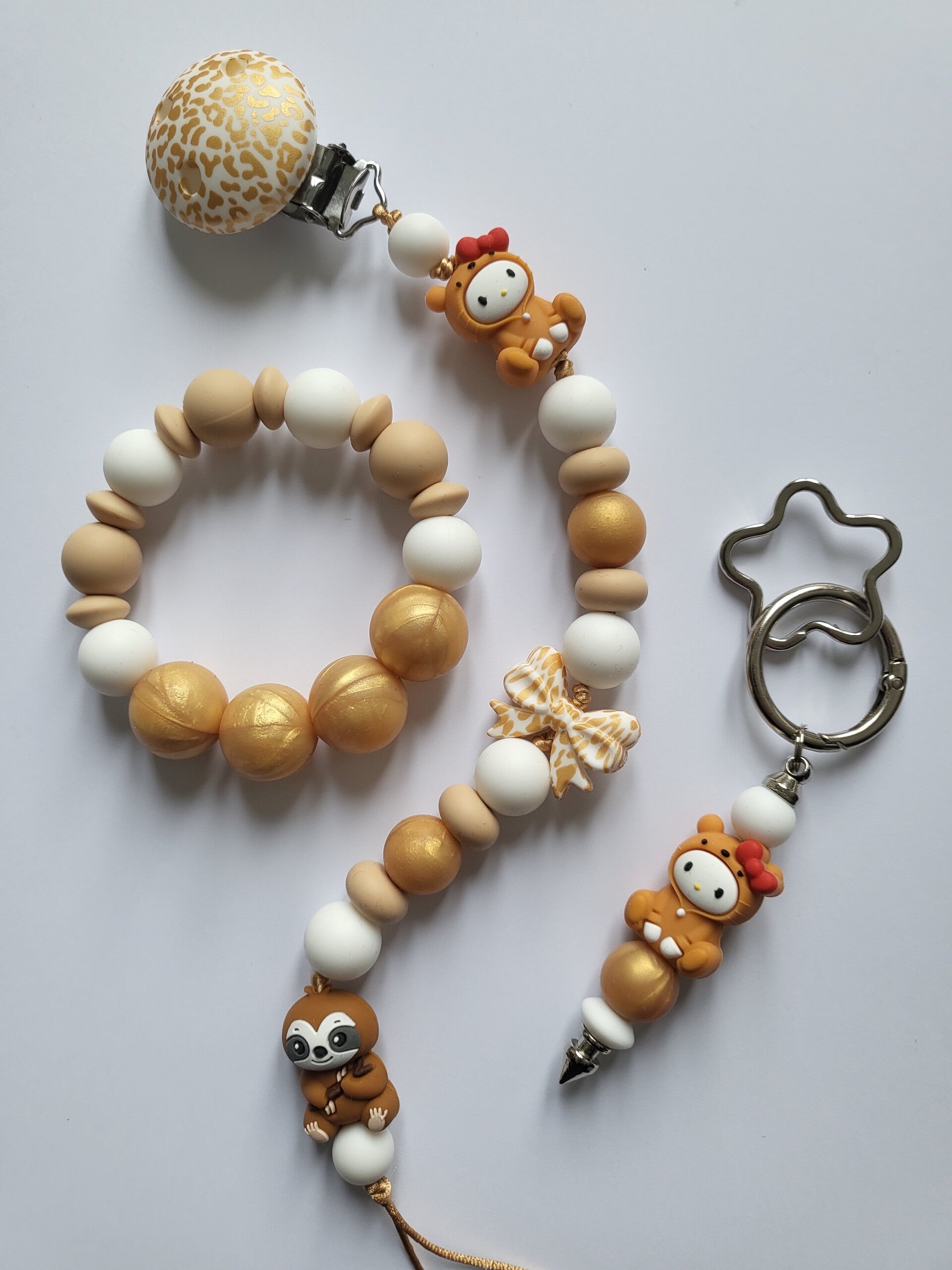 Speenkoord en bijtring met luiaard en baby in mat-goud, beige en wit.