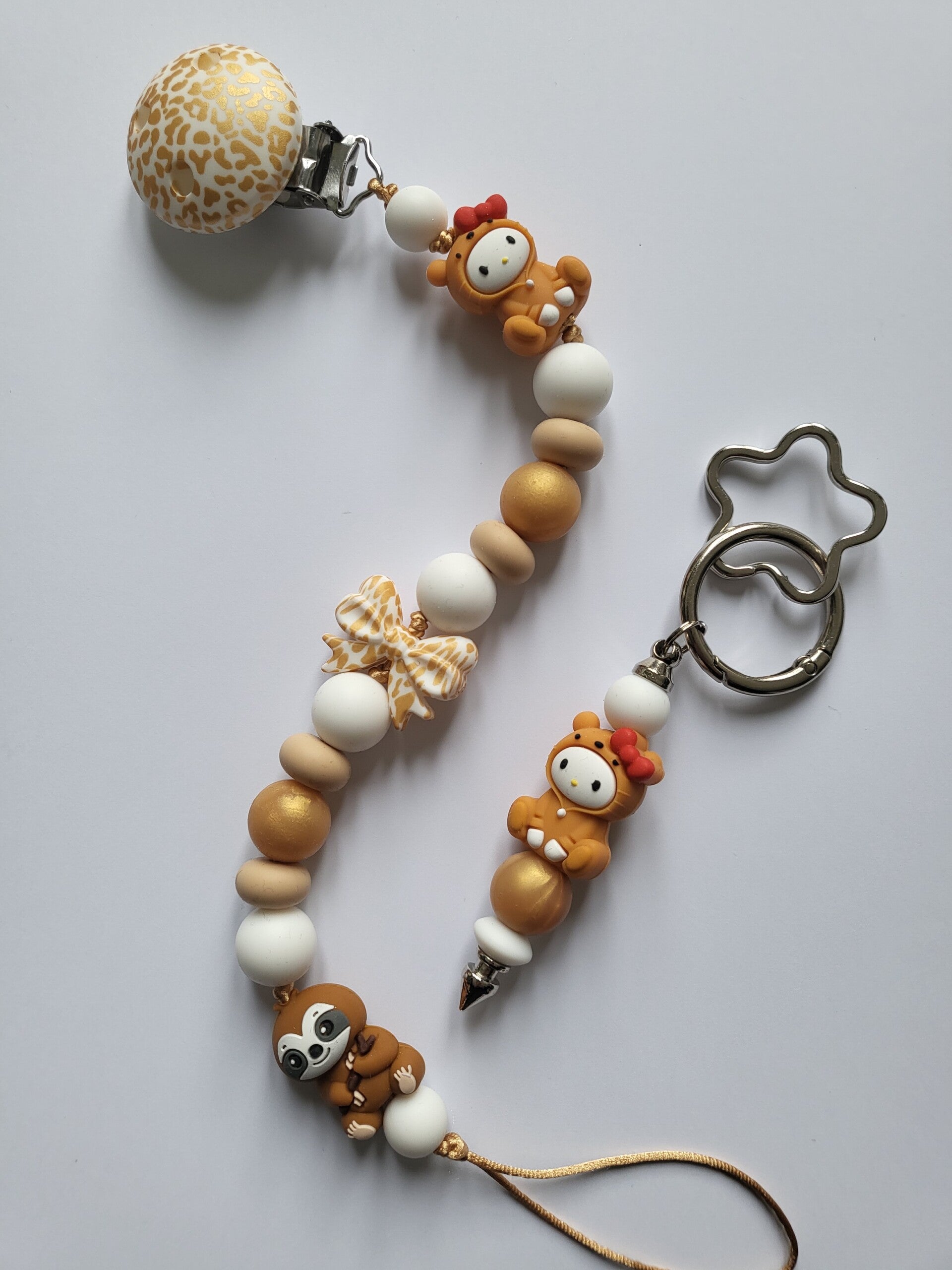 Speenkoord met luiaard en baby in mat-goud, beige en wit.
