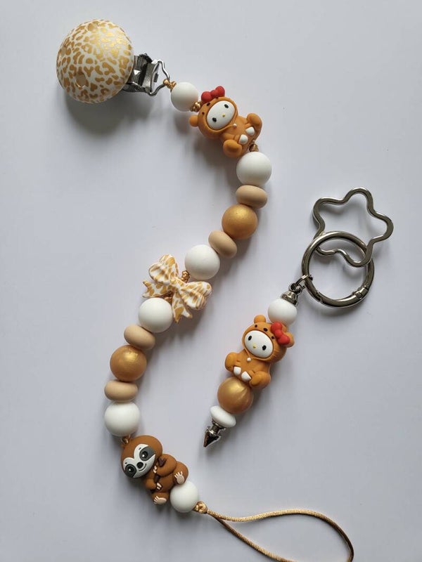 Speenkoord met luiaard en baby in mat-goud, beige en wit.