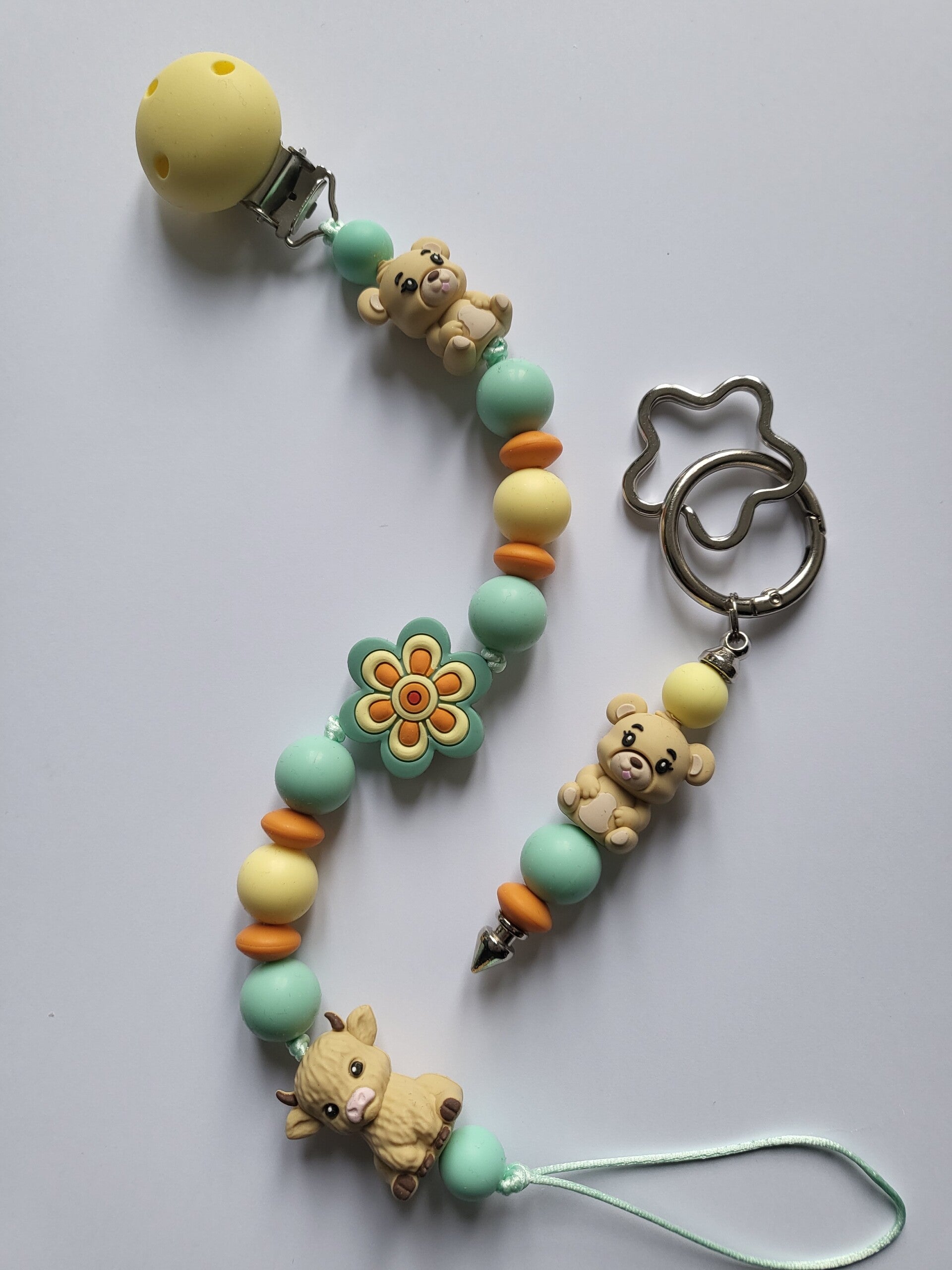 Speenkoord met koetje en beertje in lichtgeel, mintgroen, oranje en beige.