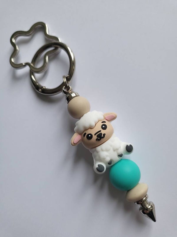 Tashanger met schaapje in turquoise, beige en wit.