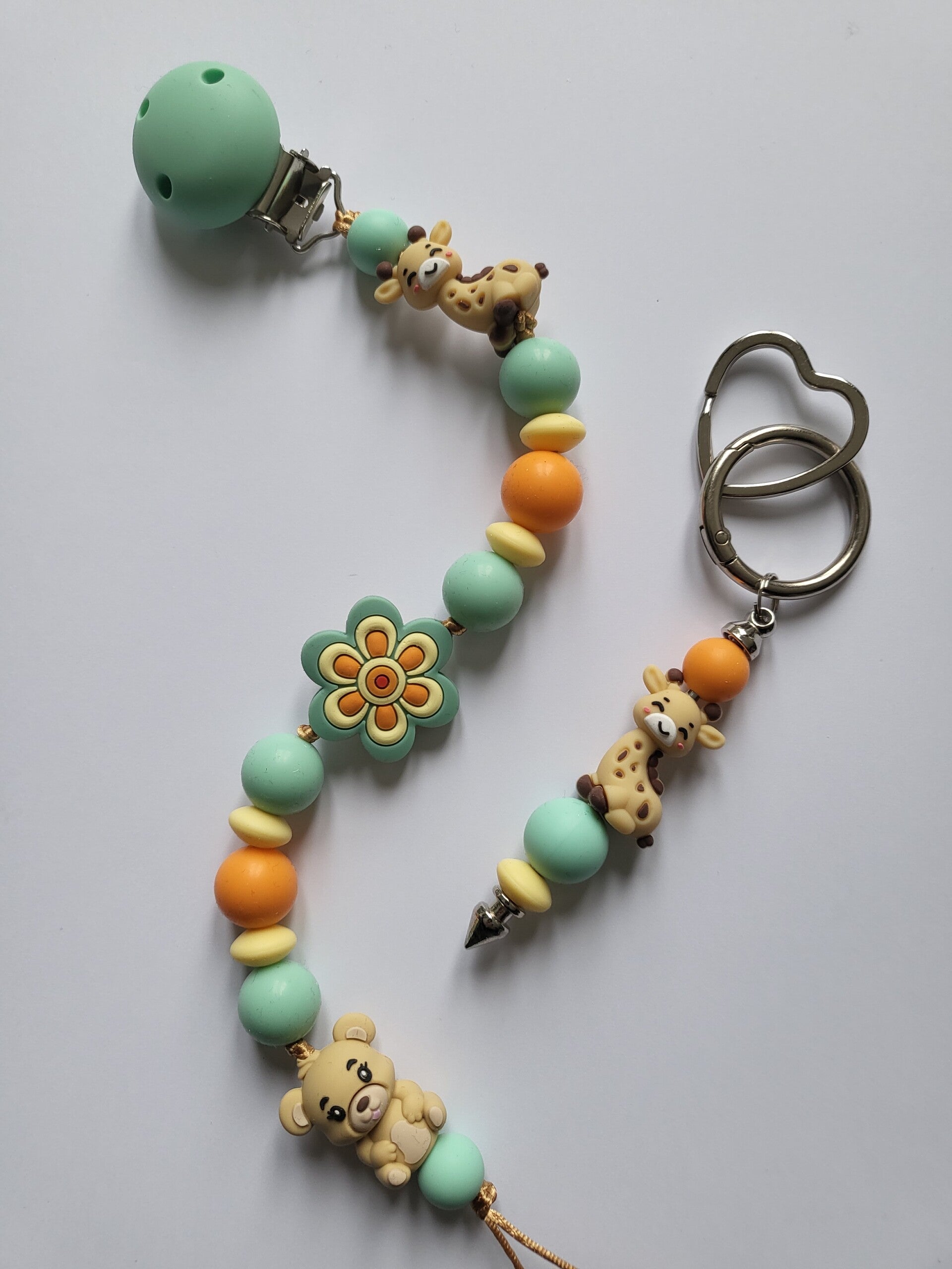 Speenkoord met girafje en beertje in mintgroen, oranje, lichtgeel en beige.