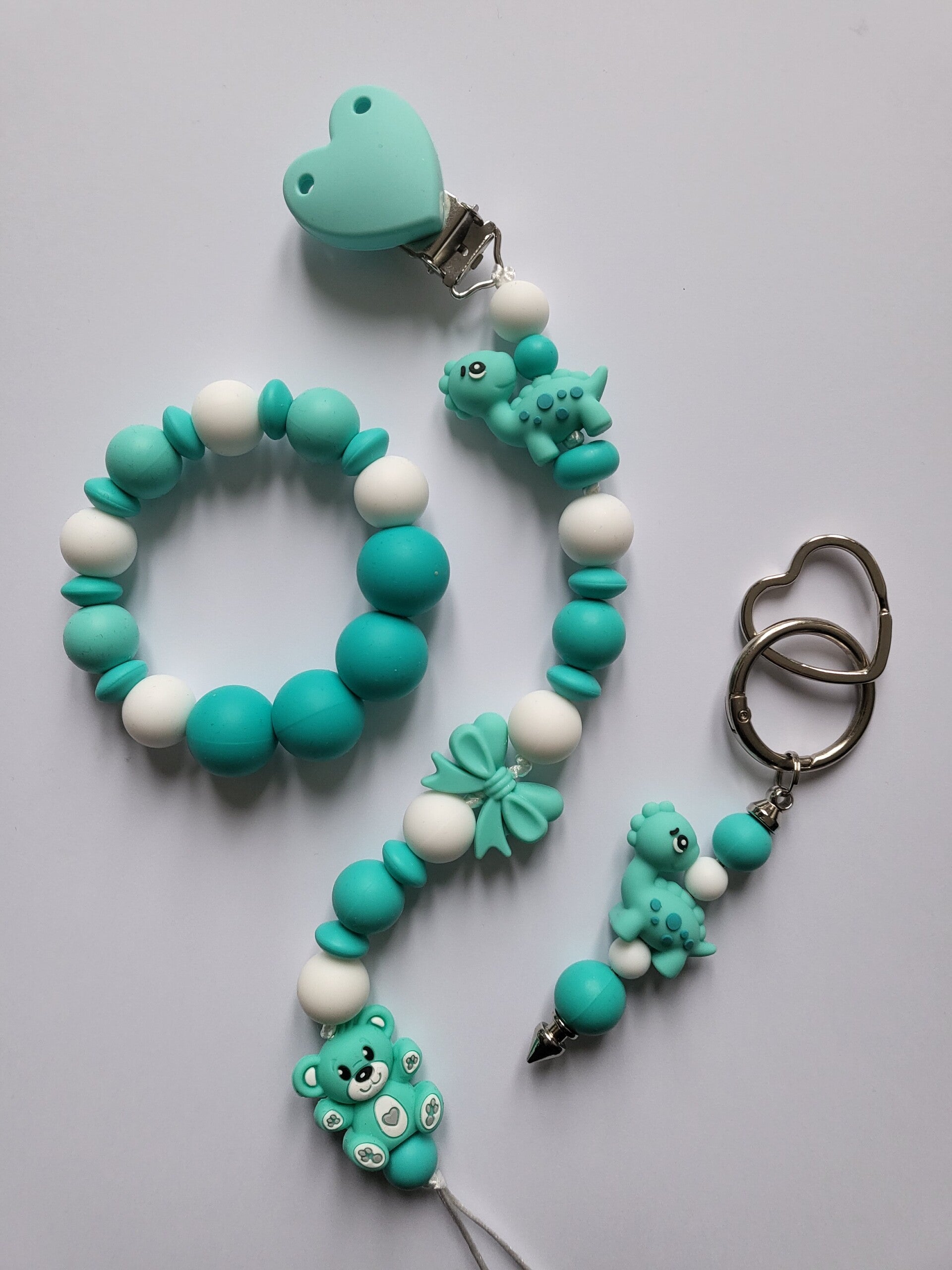 Speenkoord en bijtring met teddybeertje en dinosaurusje in mintgroen, turquoise en wit.