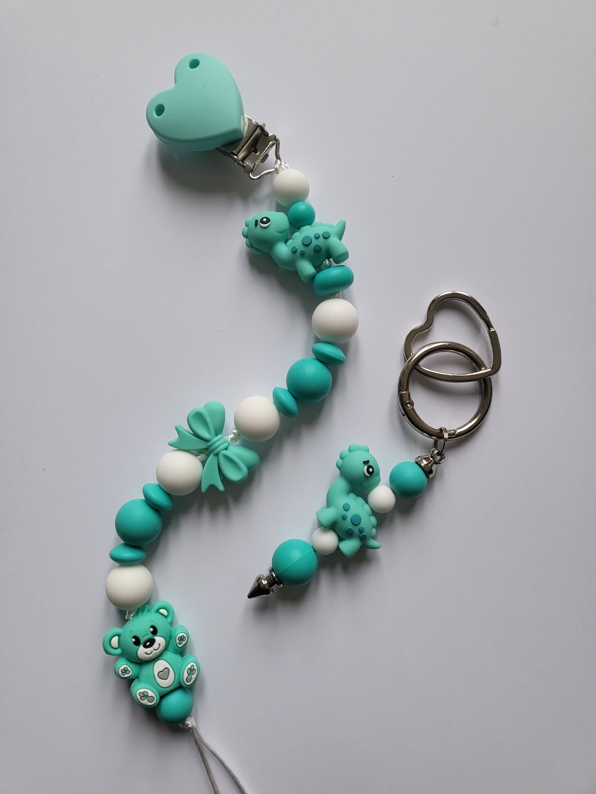Speenkoord met teddybeertje en dinosaurusje in mintgroen, turquoise en wit.