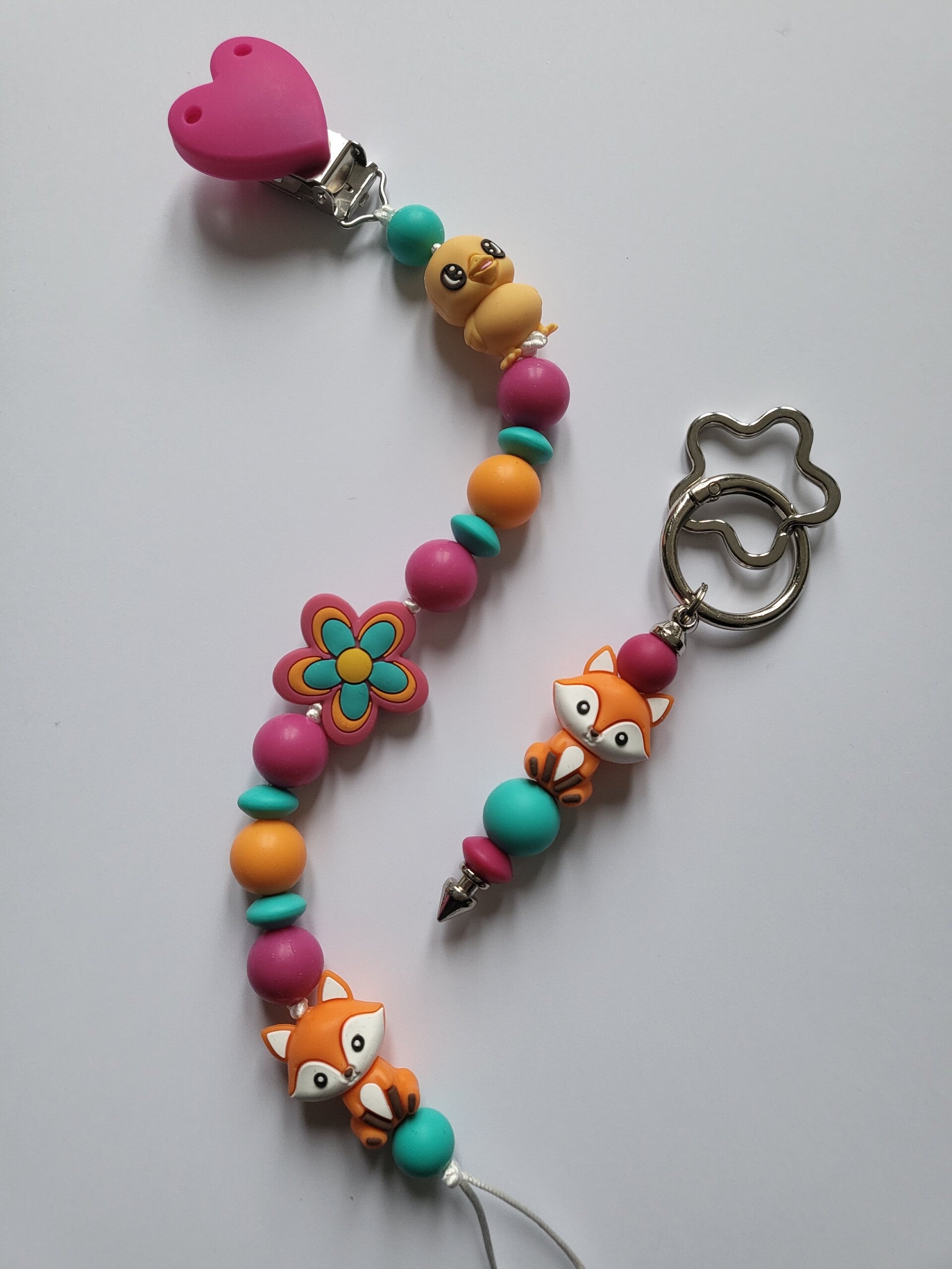 Speenkoord met kuikentje en vosje in fuchsia-roze, oranje en turquoise.